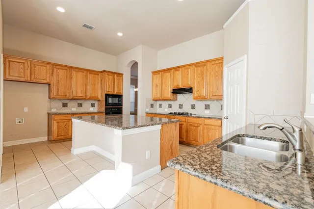a kitchen with stainless steel appliances granite countertop a sink stove and cabinets