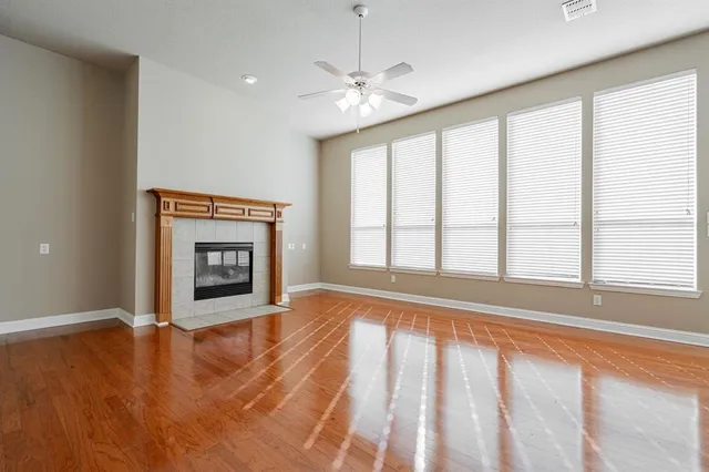 a view of an empty room with a fireplace and a window