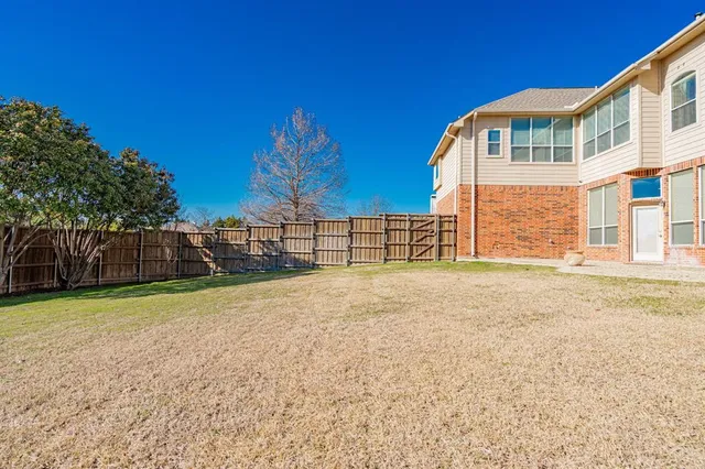 a view of a house with backyard and a tree
