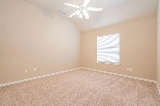 an empty room with a window and ceiling fan