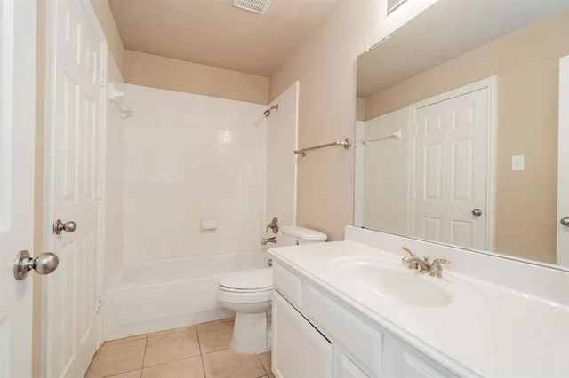 a bathroom with a bathtub shower sink vanity and a toilet