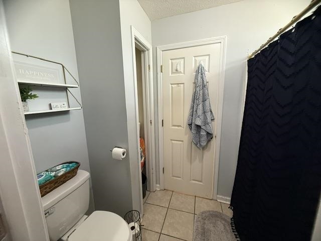 395 Austin Street Savannah, TN 38372 - Photo 13 of 32 Bathroom featuring tile flooring, a built-in toilet, and a white two-tier wall shelf