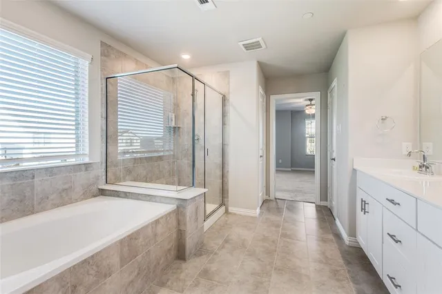 a spacious bathroom with a double vanity sink a mirror and a bathtub