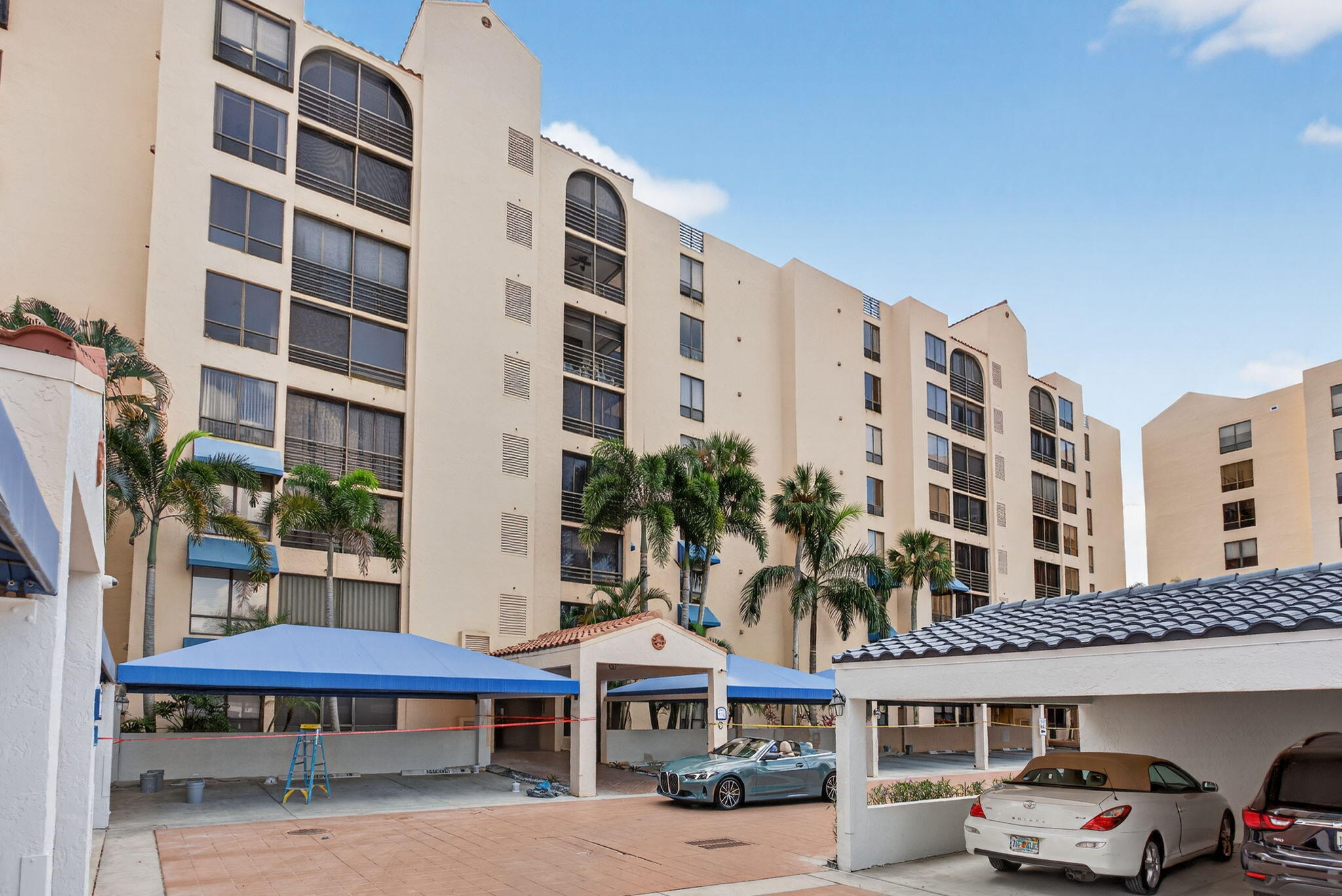 7186 Promenade Drive, Unit 701 Boca Raton, FL 33433 - Photo 1 of 39 a front view of a building with glass windows and small yard