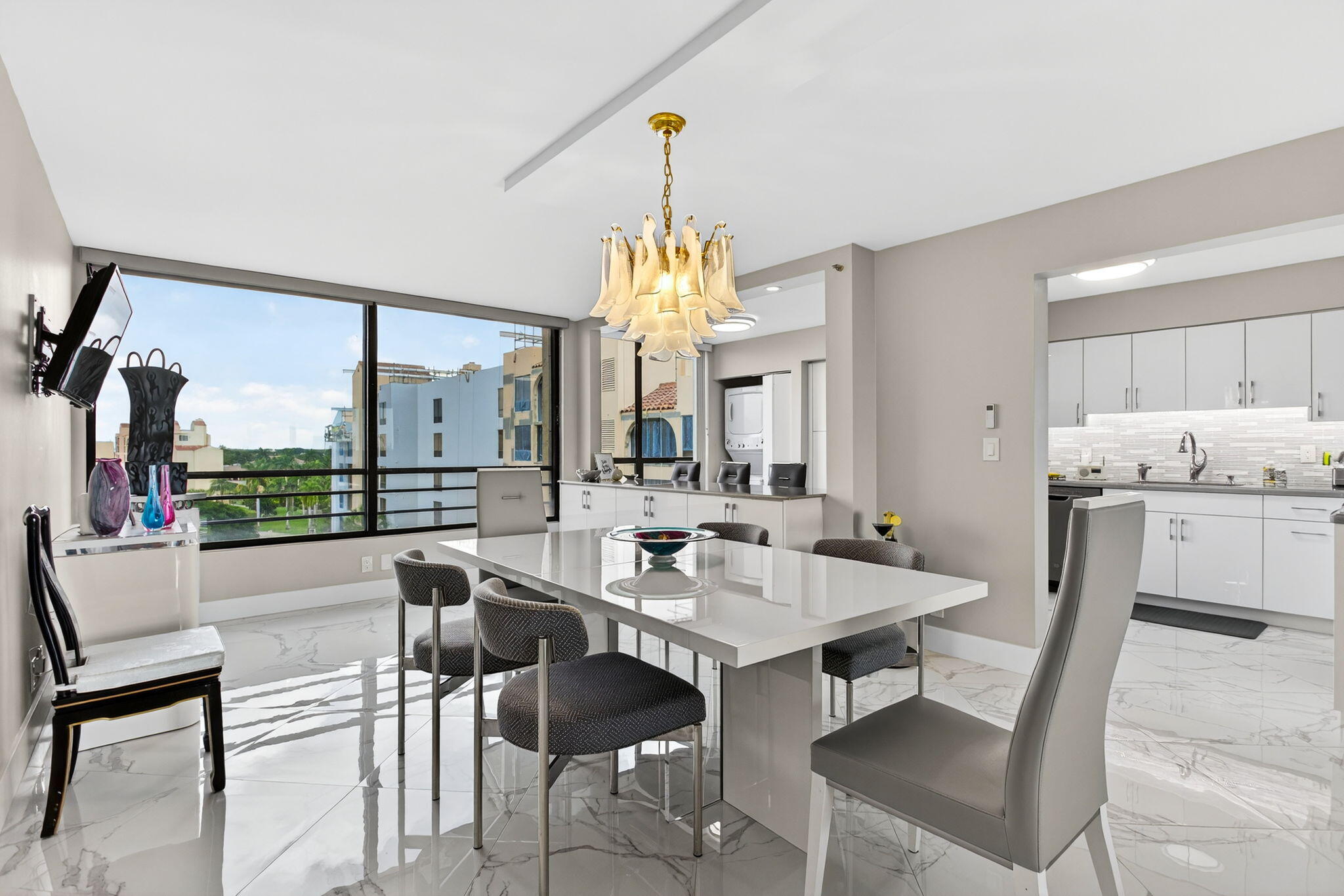 7186 Promenade Drive, Unit 701 Boca Raton, FL 33433 - Photo 14 of 39 a dining room with furniture a chandelier and a rug