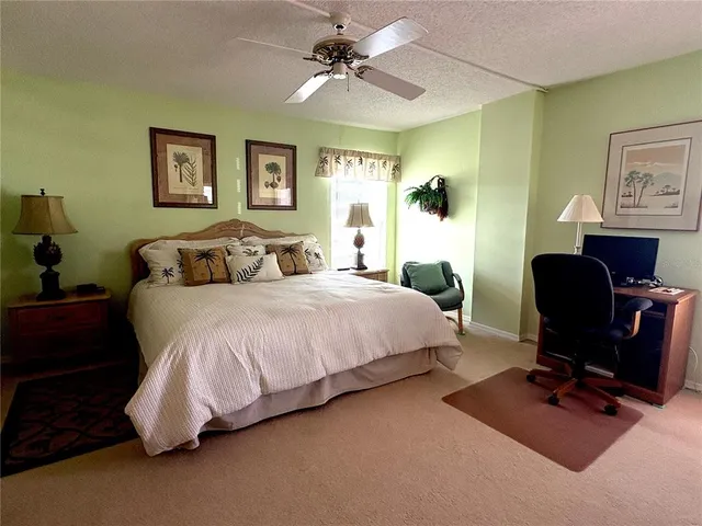 a spacious bedroom with a bed and a chandelier