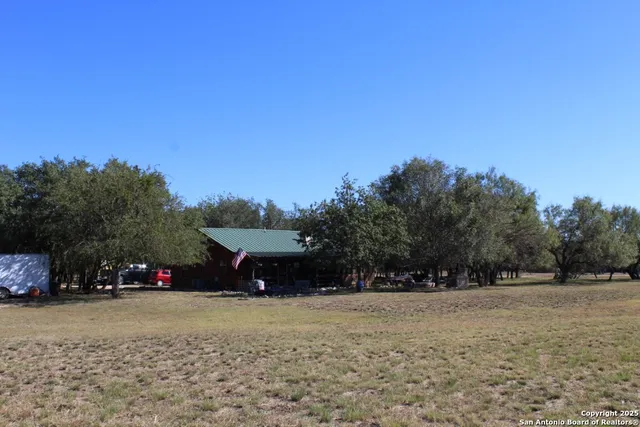 a view of empty field with trees in the background