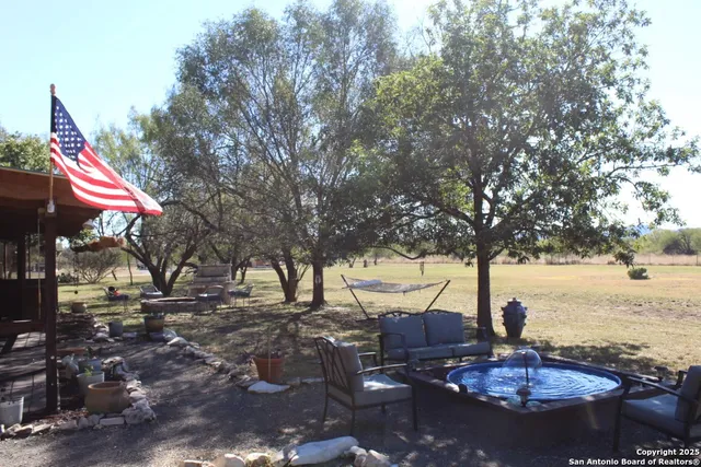 a backyard of a house with barbeque oven table and chairs