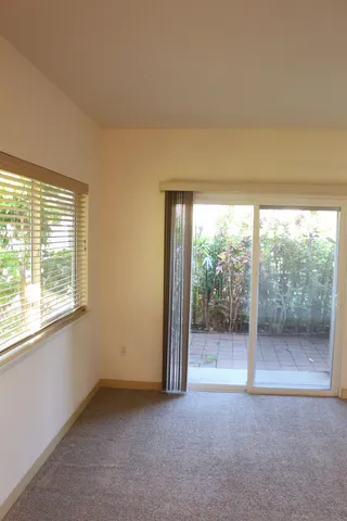 an empty room with wooden floor and glass door