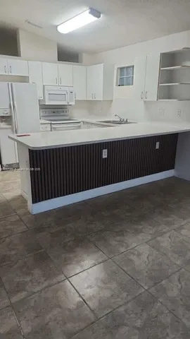 a kitchen with kitchen island cabinets and oven