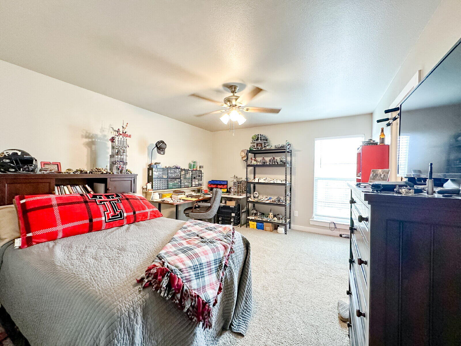 7413 35th Street Lubbock, TX 79407 - Photo 6 of 9 a bedroom with a bed and a chandelier