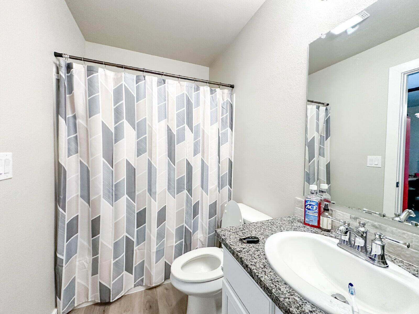 7413 35th Street Lubbock, TX 79407 - Photo 7 of 9 a bathroom with a granite countertop sink toilet and shower curtain