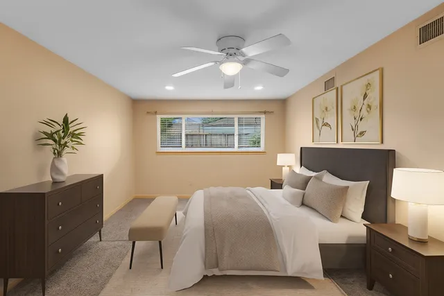 an empty room with chandelier fan and windows