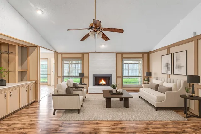 a living room with furniture fireplace and a large window