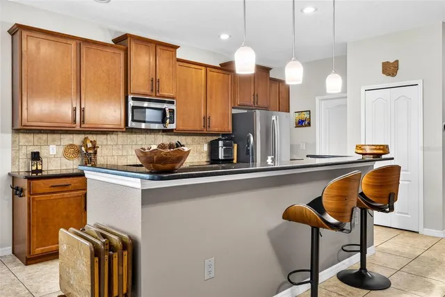 a kitchen with stainless steel appliances granite countertop a sink a stove and a refrigerator