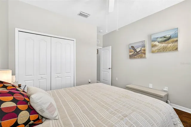 a bedroom with a bed and a painting on the wall