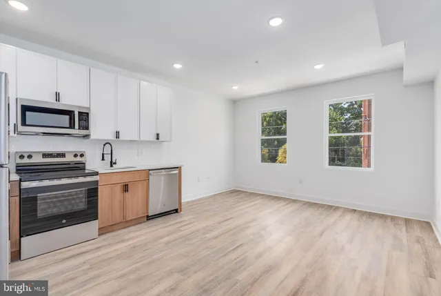 a kitchen with granite countertop a stove a sink and a microwave