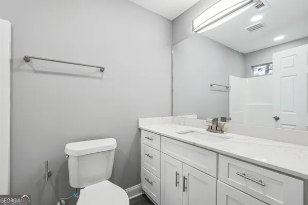 a white toilet sitting next to a bathroom sink