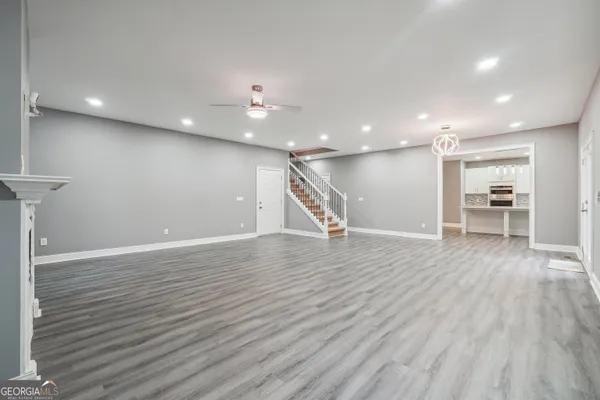 a view of a room with wooden floor stairs and a way to kitchen