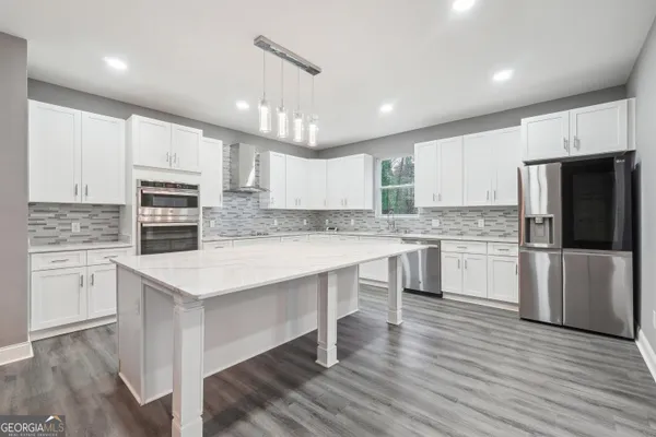 a kitchen with a refrigerator stove top oven and cabinets