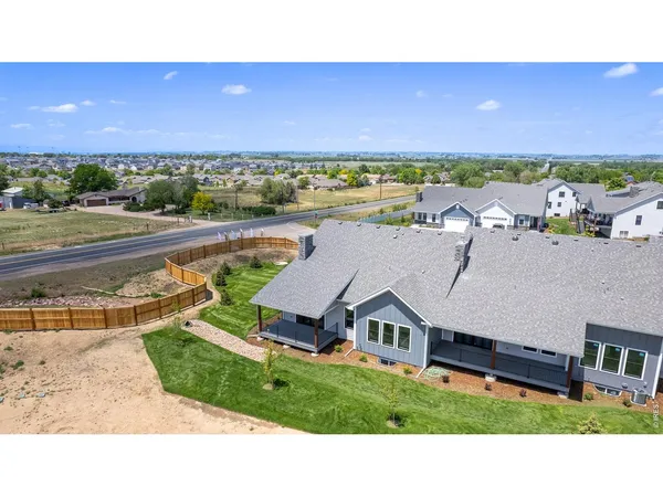 a view of a big house with a big yard and large trees