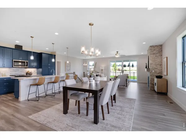 a dining room with furniture a chandelier and kitchen view
