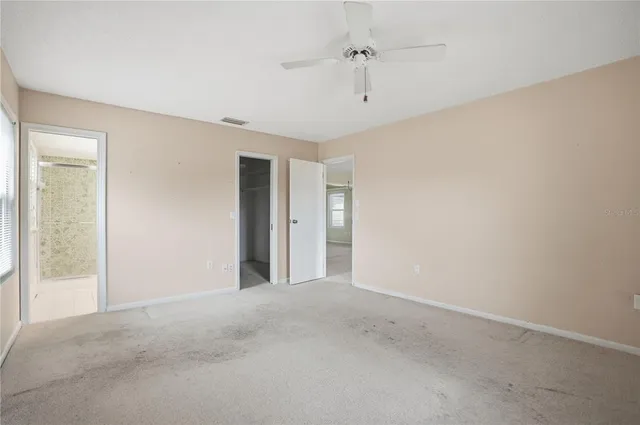 a view of a big room with windows and chandelier fan