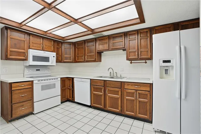 a kitchen with stainless steel appliances granite countertop a refrigerator and wooden cabinets