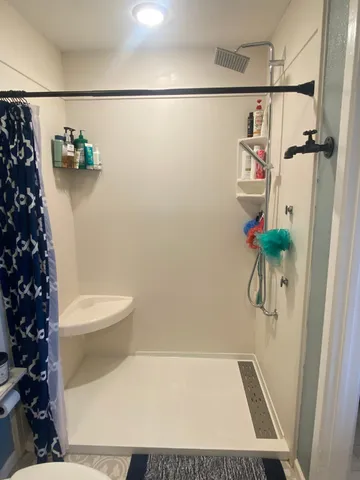 a bathroom with a toilet and a shower
