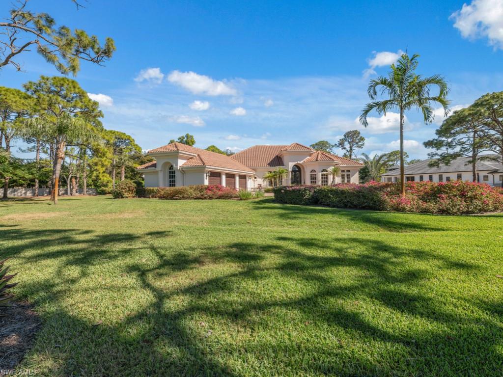 506 Ridge Drive Naples, FL 34108 - Photo 2 of 33 View of grassy yard featuring a garage