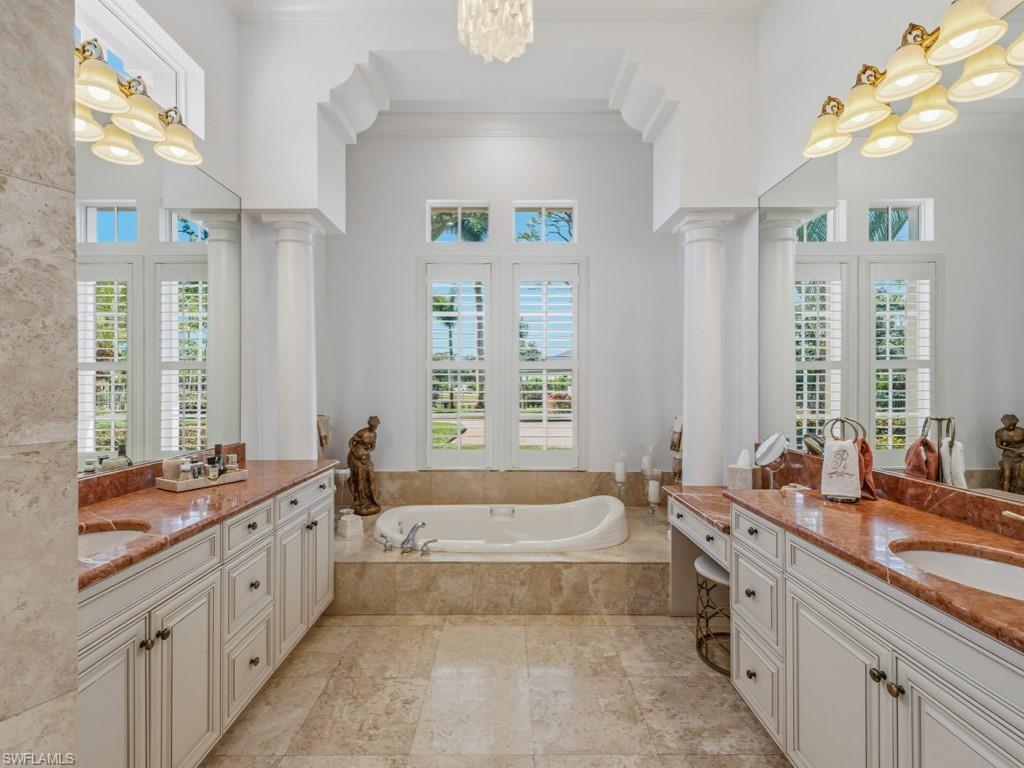 506 Ridge Drive Naples, FL 34108 - Photo 26 of 33 Full bath featuring a chandelier, a garden tub, two vanities, ornamental molding, and healthy amount of natural light