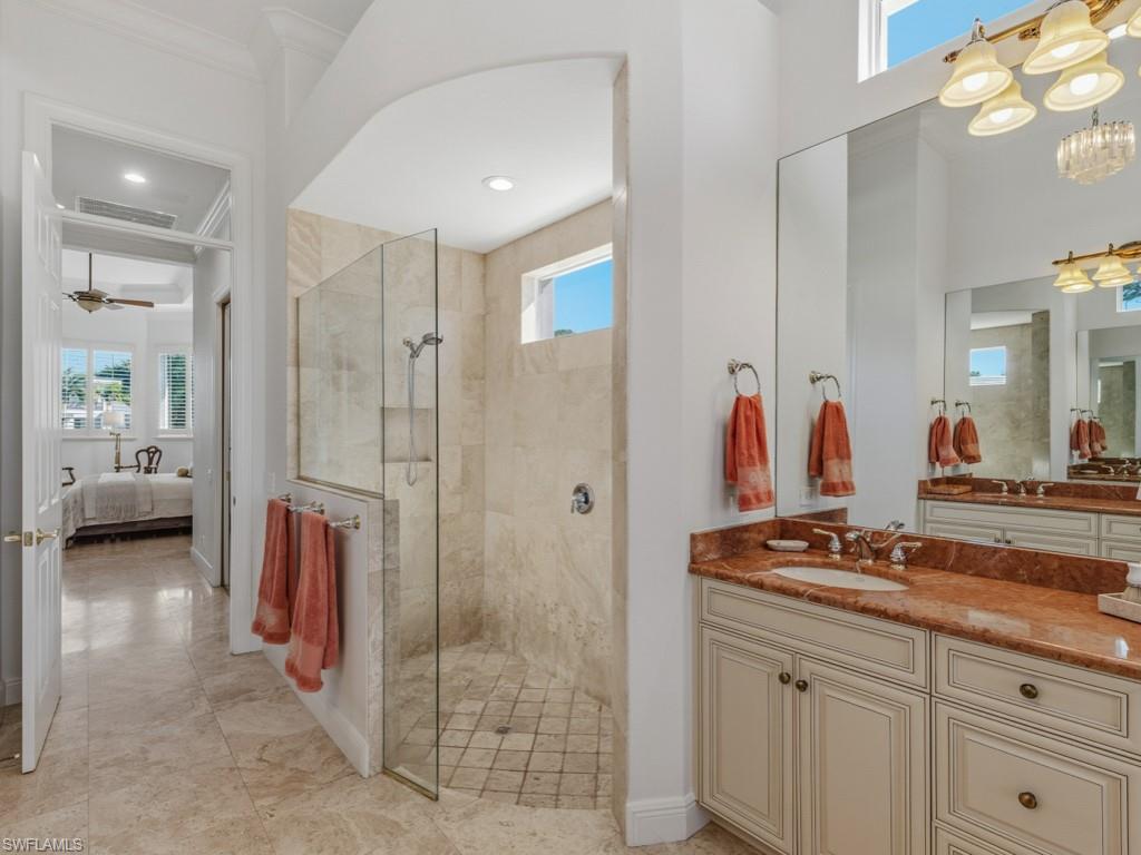 506 Ridge Drive Naples, FL 34108 - Photo 27 of 33 Ensuite bathroom with plenty of natural light, vanity, walk in shower, and ceiling fan