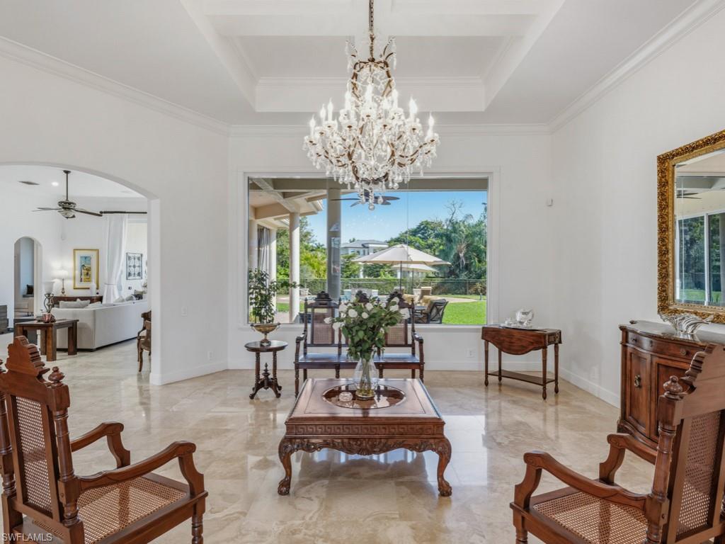 506 Ridge Drive Naples, FL 34108 - Photo 6 of 33 Living area with ceiling fan, arched walkways, marble tiled flooring, ornamental molding, and a chandelier