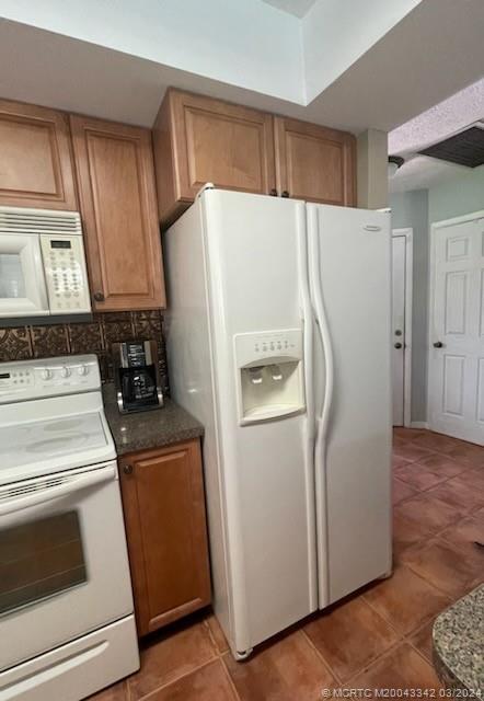 8552 Southwest 17th Avenue Stuart, FL 34997 - Photo 12 of 25 a white refrigerator freezer sitting in a kitchen