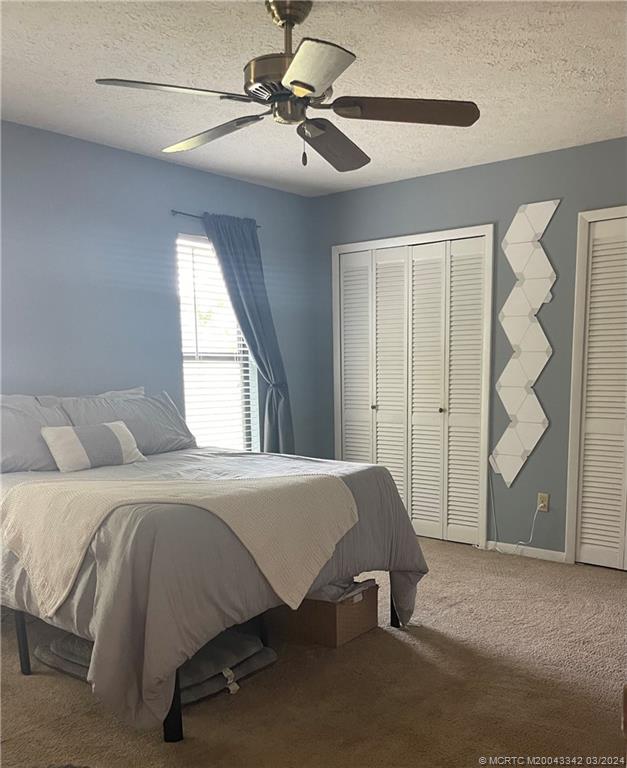 8552 Southwest 17th Avenue Stuart, FL 34997 - Photo 13 of 25 a bedroom with a bed and a chandelier