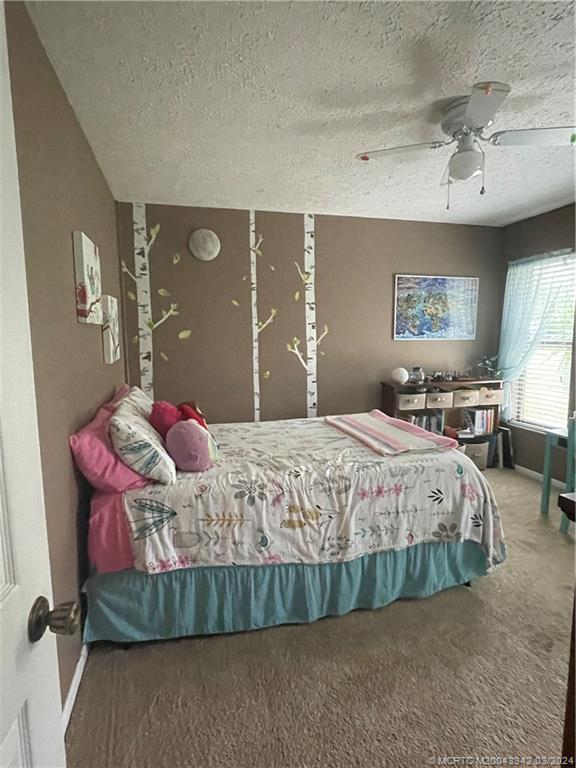 8552 Southwest 17th Avenue Stuart, FL 34997 - Photo 18 of 25 a bedroom with a bed mirror and window