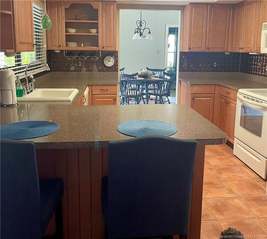 8552 Southwest 17th Avenue Stuart, FL 34997 - Photo 10 of 25 a kitchen with stainless steel appliances wooden cabinets sink and stove