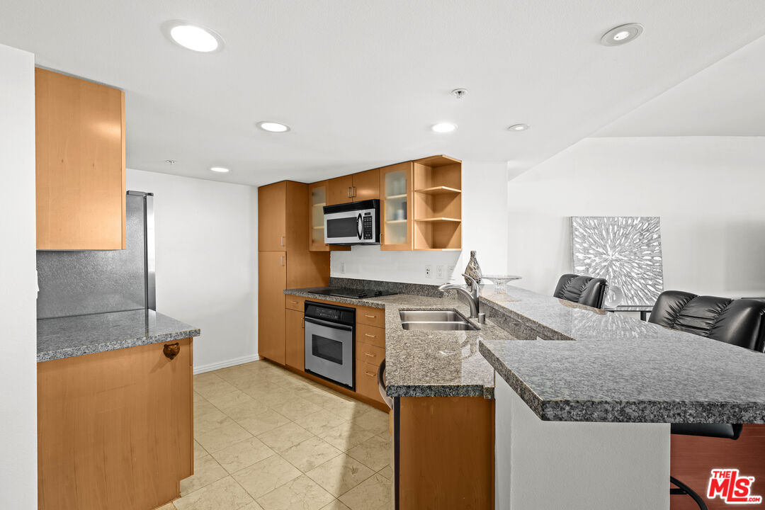 13700 Marina Pointe Drive, Unit 1007 Marina del Rey, CA 90292 - Photo 12 of 53 a kitchen with stainless steel appliances granite countertop a sink and a refrigerator