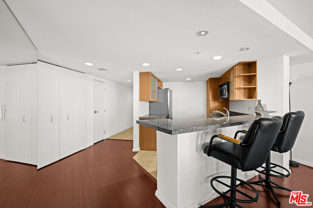 13700 Marina Pointe Drive, Unit 1007 Marina del Rey, CA 90292 - Photo 14 of 53 a kitchen with stainless steel appliances kitchen island granite countertop a stove and a refrigerator