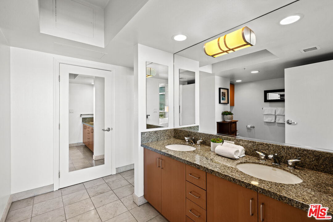 13700 Marina Pointe Drive, Unit 1007 Marina del Rey, CA 90292 - Photo 21 of 53 a spacious bathroom with a granite countertop sink and a mirror