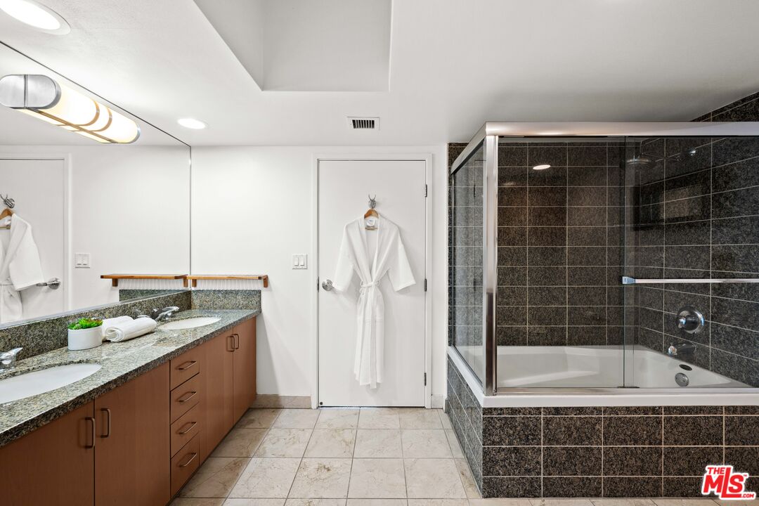 13700 Marina Pointe Drive, Unit 1007 Marina del Rey, CA 90292 - Photo 22 of 53 a bathroom with a granite countertop sink a toilet and bathtub