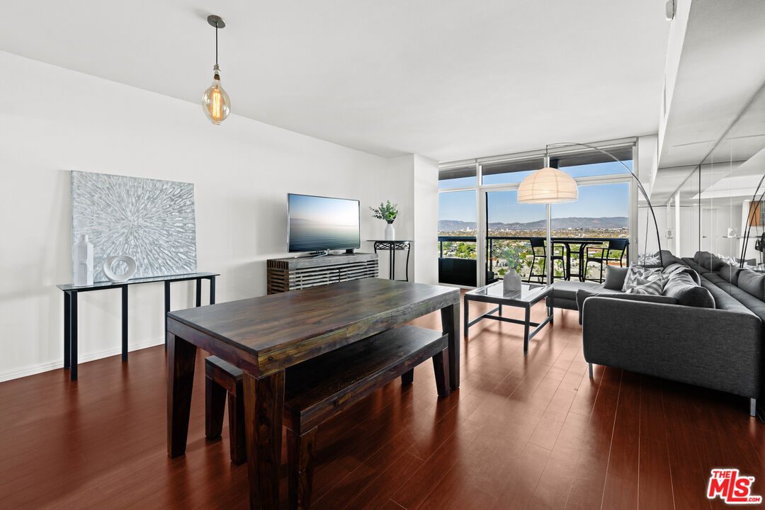 13700 Marina Pointe Drive, Unit 1007 Marina del Rey, CA 90292 - Photo 7 of 53 a dining room with wooden floor a chandelier a glass table and chairs