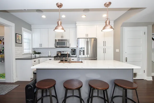 a kitchen with stainless steel appliances a table and chairs in it