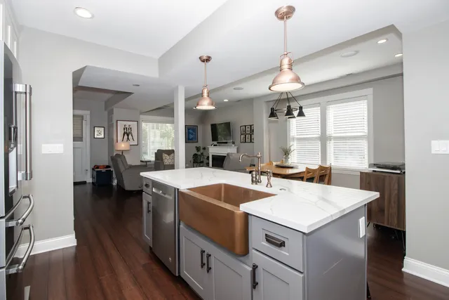 a kitchen that has a lot of cabinets a sink and wooden floor