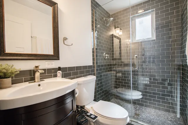 a bathroom with a sink mirror toilet and shower