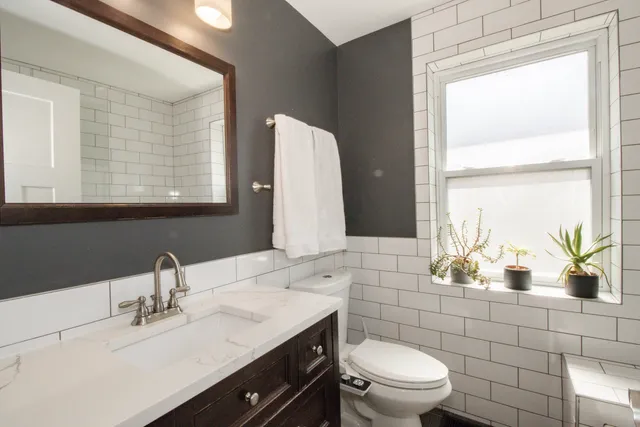 a bathroom with a sink a toilet and mirror