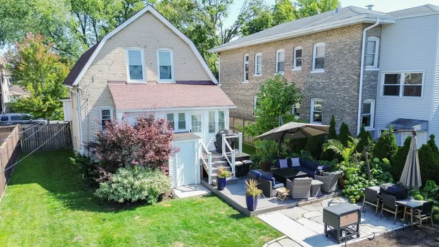 a view of a house with backyard and sitting area