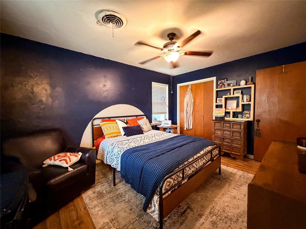 1706 North Ave H Haskell, TX 79521 - Photo 22 of 25 a spacious bedroom with a bed and a chandelier