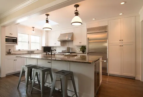 a kitchen with granite countertop a sink a counter top space and living room view