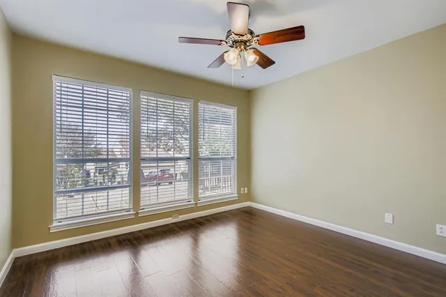 a view of a livingroom with wooden floor and a ceiling fan